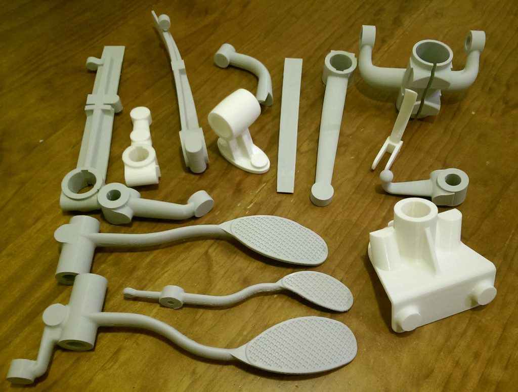 A batch of 3D printed car parts, designed in CAD and printed in PLA ready to be cast in metal.